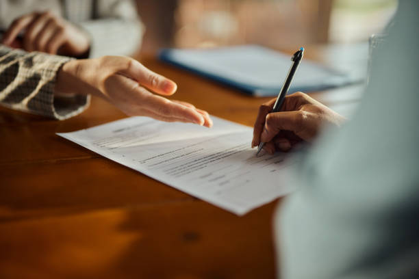 A person is writing on a document