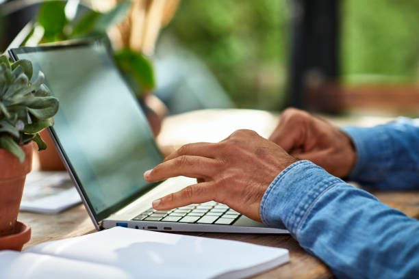A person is typing on a laptop keyboard
